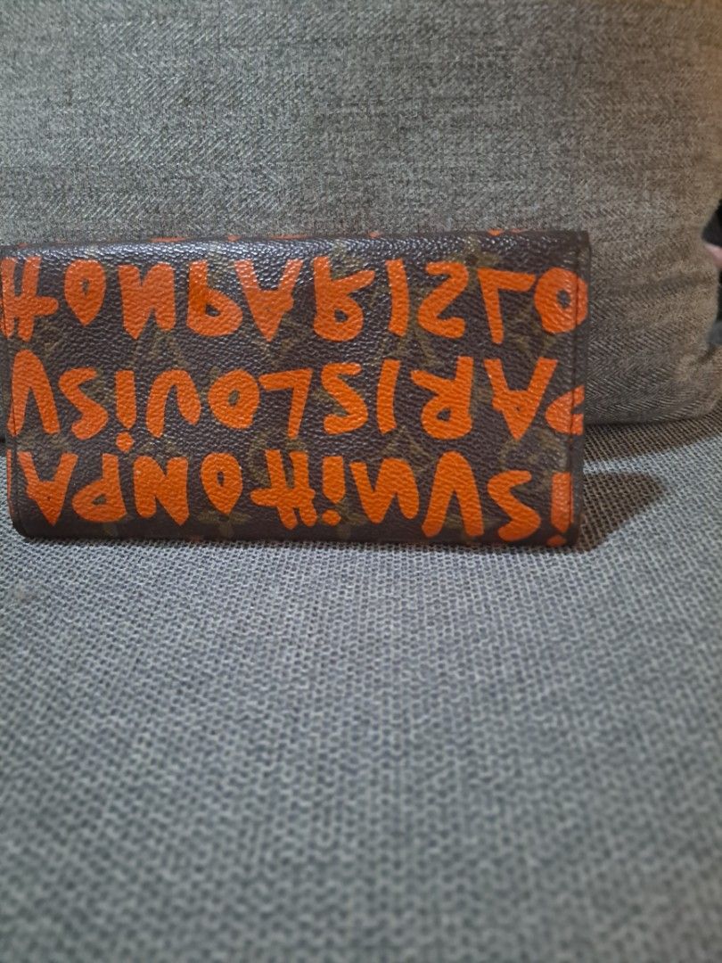 Louis Vuitton Graffiti Wallet (Category: Luxury Bags & Wallets) located in Cebu City. Submitted by atetskie (Listing ID 1408001622, Image 1). Description: - Louis Vuitton wallet - Features the iconic graffiti design - Classic LV monogram exterior with orange graffiti - Orange interior - Multiple card slots - Clear ID window - Snap closure - Made in France.