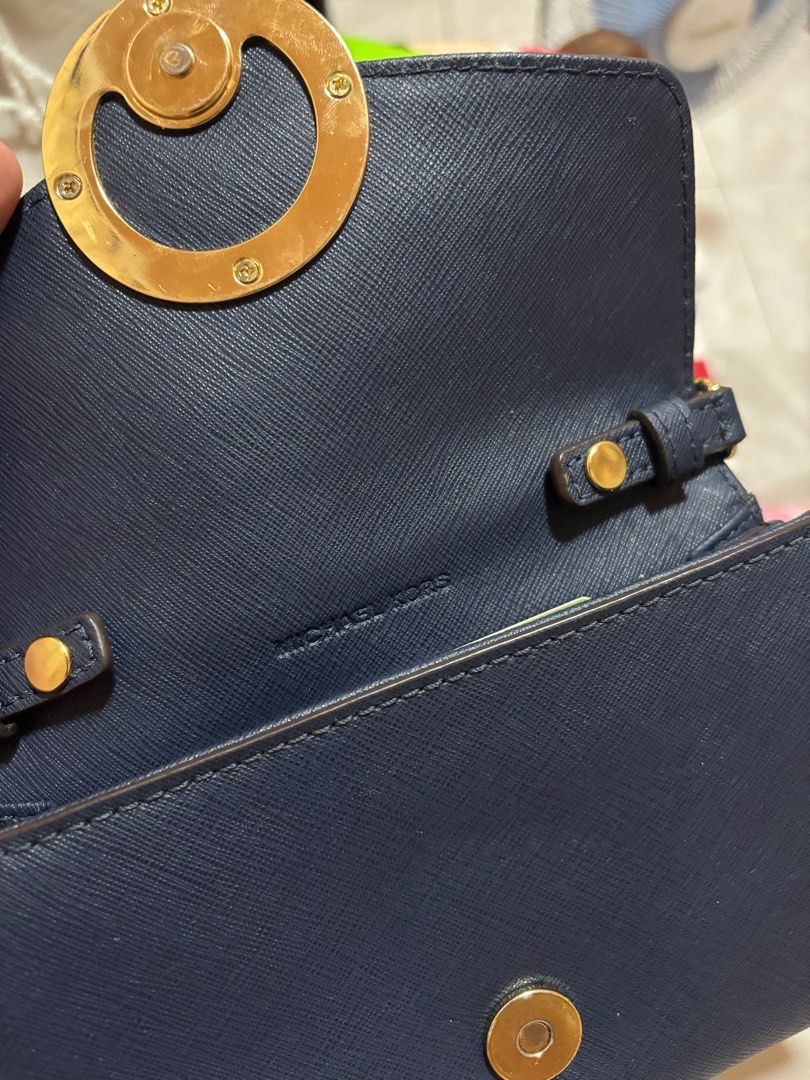 Michael Kors Navy Blue Crossbody Bag (Category: Luxury Bags & Wallets) located in Tacloban City. Submitted by ceegieca (Listing ID 1408042653, Image 3). Description: Navy blue Michael Kors crossbody bag with a gold-tone MK logo. Features a chain strap and a flap closure. The interior is navy blue with the Michael Kors logo visible. The strap is adjustable..
