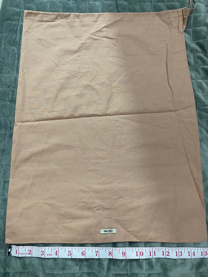 Miu Miu Dust Bag (Category: Luxury Bags & Wallets) located in Manila. Submitted by angeliemataro25 (Listing ID 1407973982, Image 1). Description: - Authentic Miu Miu dust bag - Color: Light brown - Dimensions: Approximately 14 inches (length) x 9 inches (width) - Closure: Drawstring - Features the Miu Miu logo.