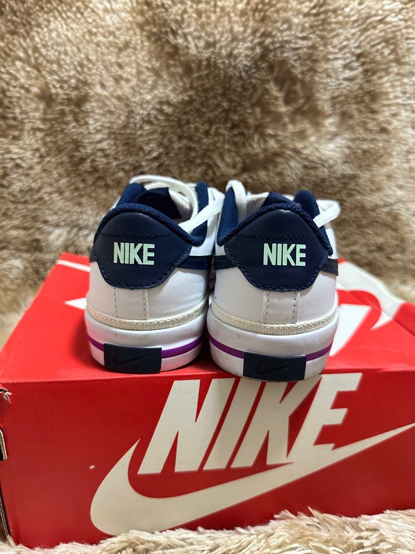 Nike Court Legacy (GS) (Category: Babies & Kids Fashion) located in Cainta. Submitted by kath_pl (Listing ID 1407950758, Image 2). Description: - Nike Court Legacy (GS) sneakers - Color: White with navy accents - Features a navy swoosh and purple sole stripe - Size: 4Y (UK 3.5, CM 23) - Made in Vietnam - Condition: Good.