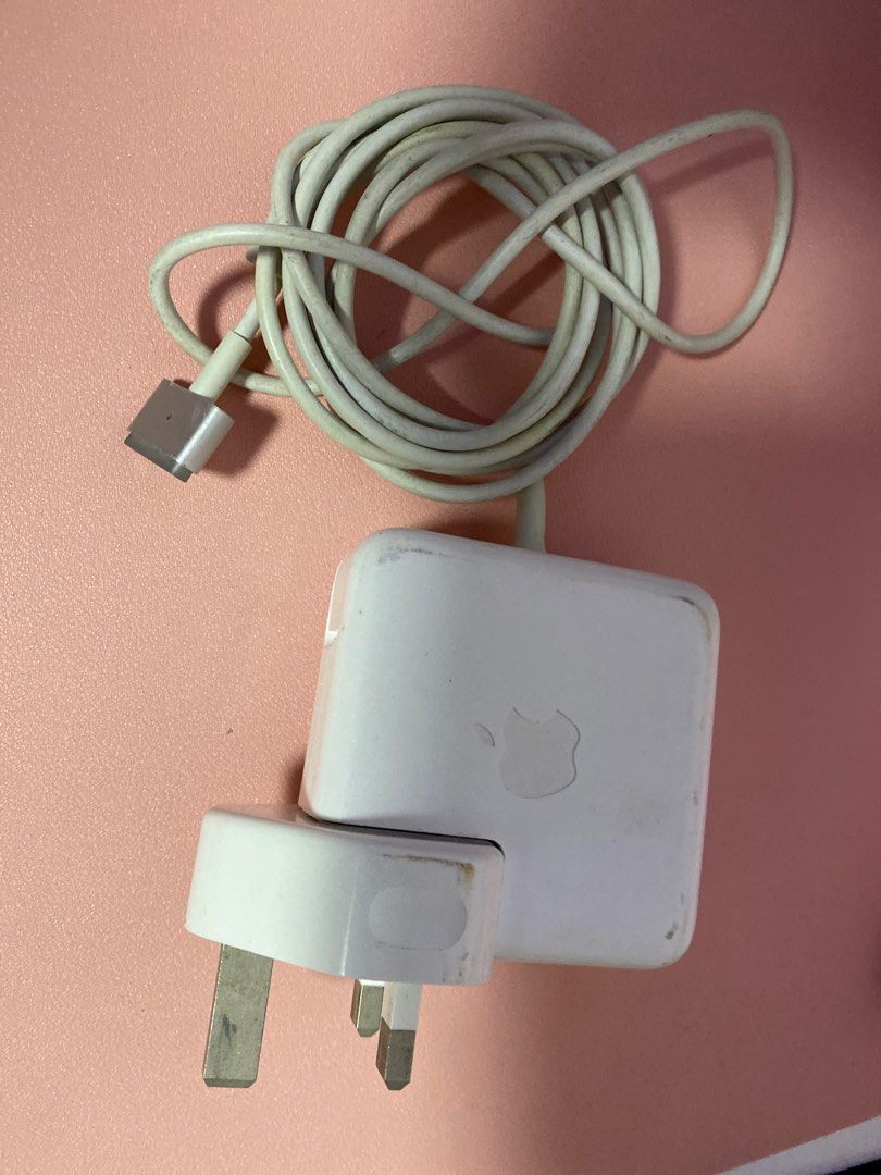 Original Apple Macbook Charger (Category: Chargers & Cables) located in Paniqui. Submitted by daily_finds (Listing ID 1408064871, Image 1). Description: - Apple Macbook charger - MagSafe connector - White charger and cable - Three-pin plug - Apple logo visible - Coiled cable - Functional.