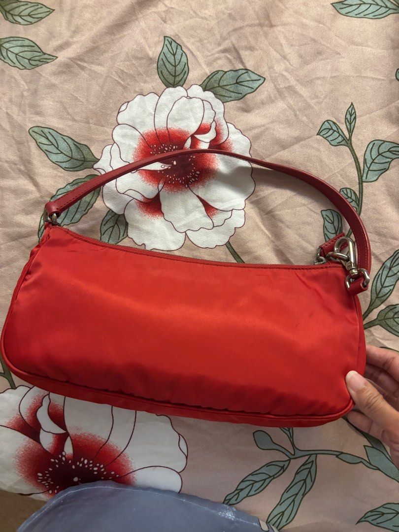 Prada Red Nylon Shoulder Bag (Category: Luxury Bags & Wallets) located in Quezon City. Submitted by myvintagefinds (Listing ID 1407941101, Image 3). Description: - Authentic Prada shoulder bag - Red nylon exterior - Silver-tone zipper with Prada logo - Orange interior lining - Small Prada logo on exterior - Single shoulder strap - Prada Milano label inside - Tag number: 165.