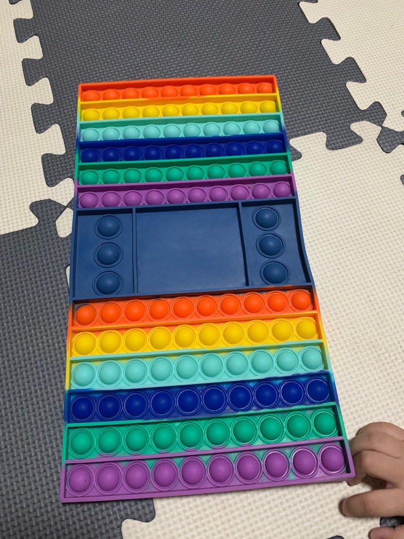 Rainbow Pop It Fidget Toy (Category: Educational & Learning Toys) located in Cavite. Submitted by rwyanewade39874 (Listing ID 1407942209, Image 2). Description: - Large, rectangular rainbow Pop It fidget toy. - Features multiple rows of colorful bubbles. - Includes a blue section with additional bubble features. - Designed for sensory play and stress relief. - Fun and engaging for kids and adults..