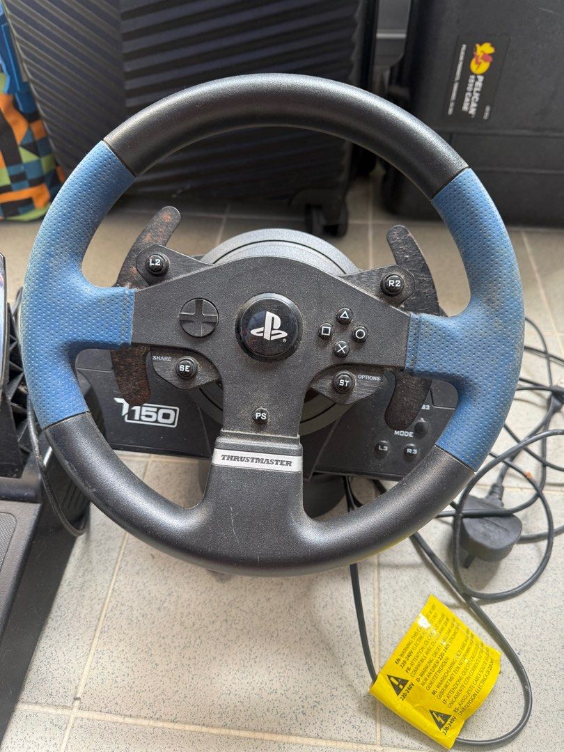 Thrustmaster T150 方向盤 （分類：手掣）位於 Hong Kong。 由 matthew5130 提交（商品編號 1407980335，圖片 2）。簡介： Thrustmaster T150 方向盤，配有腳踏板。方向盤上有 PlayStation 按鈕。方向盤的藍色部分有磨損痕跡，L2 按鈕附近有鏽跡。腳踏板有三個，金屬表面有使用痕跡。 正常操作。