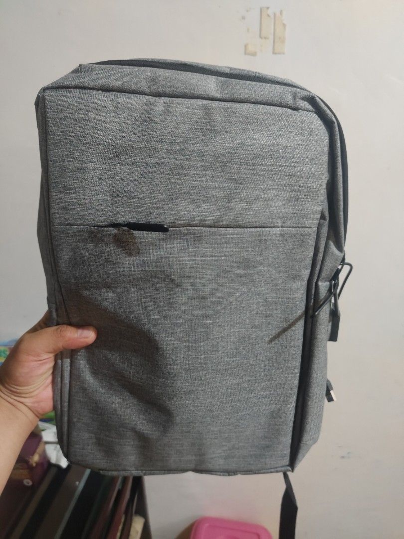 Gray Backpack (Category: Backpacks) located in Manila. Submitted by deleonaj182 (Listing ID 1408122295, Image 1). Description: - Gray backpack - Brand New - Front pocket - Adjustable straps - Spacious interior with multiple compartments - Durable material - Sleek design - Dimensions: Approximately 12" wide x 16" tall - Suitable for everyday use.