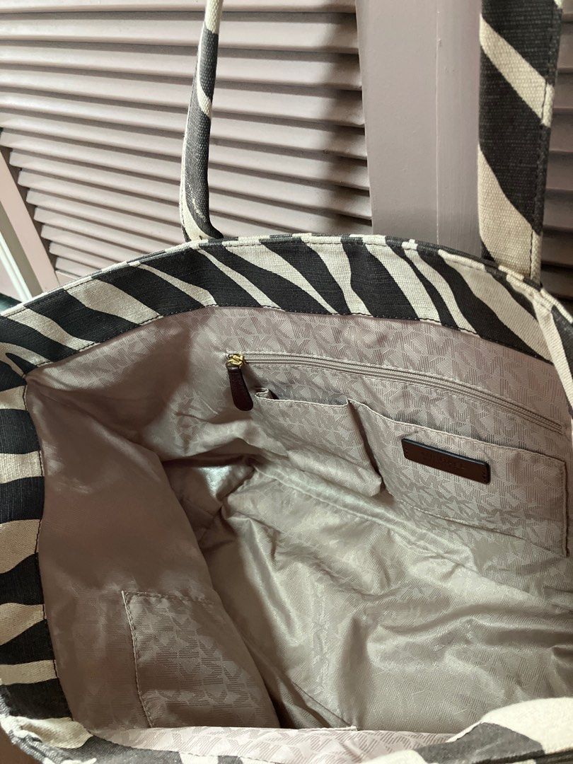 Michael Kors Zebra Print Tote Bag (Category: Tote Bags) located in Binan City. Submitted by mrsjca (Listing ID 1408174885, Image 3). Description: - Michael Kors zebra print tote bag - Brown leather handles and accents - Interior with multiple pockets and zippered compartment - Spacious design - Michael Kors logo lining - open top, no zipper - Approx. 21” on top and 15” on the bottom L x 12” H x 7” W - 9” handle drop - few stains on body, barely n
