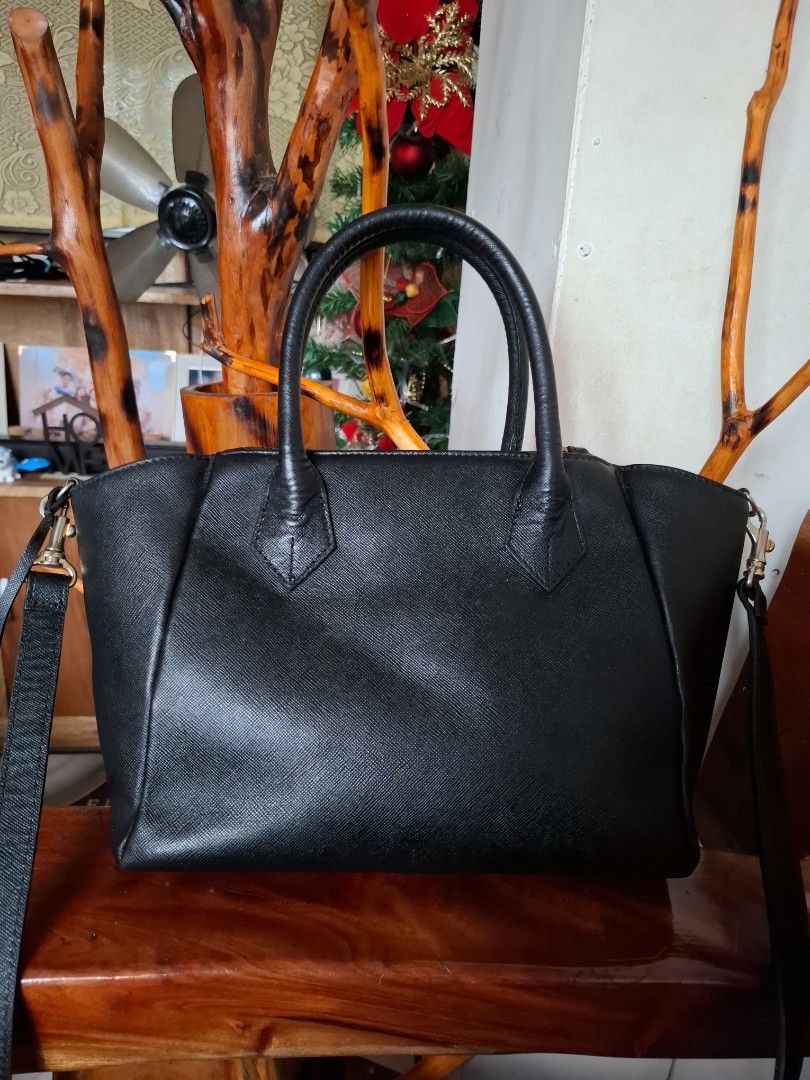 Samantha Thavasa Black Handbag (Category: Luxury Bags & Wallets) located in Libon. Submitted by jaladzarmi80045 (Listing ID 1408196315, Image 3). Description: - Brand: Samantha Thavasa - Color: Black - Features: - Top handle - Detachable shoulder strap - Gold-tone lock closure - Textured finish - Gold zipper - Additional details: Metal feet on the bottom.