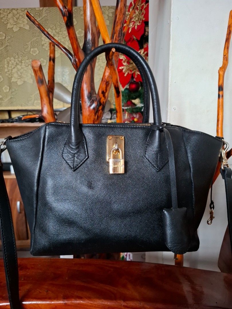 Samantha Thavasa Black Handbag (Category: Luxury Bags & Wallets) located in Libon. Submitted by jaladzarmi80045 (Listing ID 1408196315, Image 2). Description: - Brand: Samantha Thavasa - Color: Black - Features: - Top handle - Detachable shoulder strap - Gold-tone lock closure - Textured finish - Gold zipper - Additional details: Metal feet on the bottom.