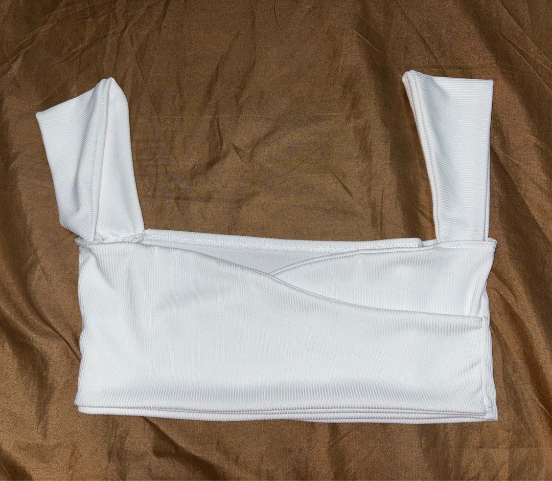 White Ribbed Crop Top (Category: Sleeveless) located in Angono. Submitted by kalidope (Listing ID 1408248224, Image 2). Description: - White ribbed crop top - Square neckline - Thick straps - Wrap-style bust - Fitted style - Ribbed knit material - Versatile for casual or night out looks.