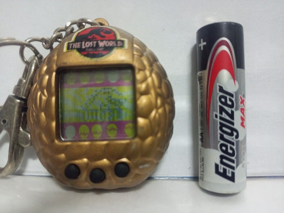 1997 Jurassic Park Lost World Vitual Pet Game (Category: Action & Battle Toys) located in Quezon City. Submitted by mackylolz (Listing ID 1408332248, Image 3). Description: 1997 Jurassic Park Lost World Vitual Pet Game Working and Tested 2pcs LR44 Battery (Not included) Have some Minimal Paint chip What you See is what u Get Pls See pic for Details.