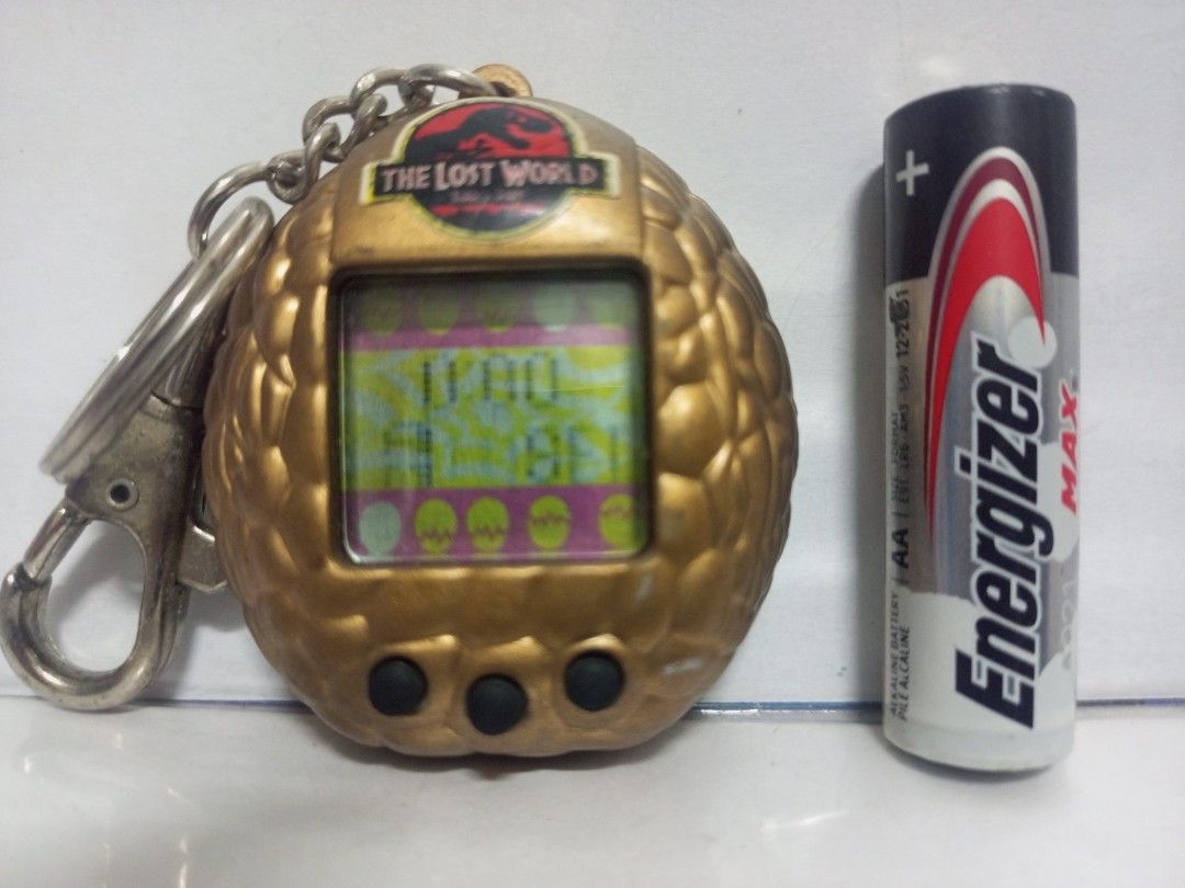 1997 Jurassic Park Lost World Vitual Pet Game (Category: Action & Battle Toys) located in Quezon City. Submitted by mackylolz (Listing ID 1408332248, Image 2). Description: 1997 Jurassic Park Lost World Vitual Pet Game Working and Tested 2pcs LR44 Battery (Not included) Have some Minimal Paint chip What you See is what u Get Pls See pic for Details.