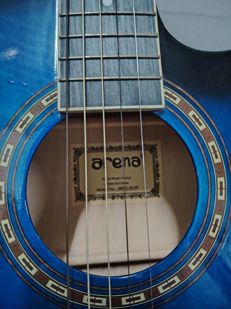 Arena Acoustic Guitar with Case (Category: Musical Instruments) located in Navotas City. Submitted by focalpoint2782 (Listing ID 1408437758, Image 3). Description: Arena acoustic guitar features a striking blue finish. It comes with a carrying case and a guitar capo. The guitar has six strings and a standard ex fretboard. The Arena logo is visible on the headstock. Mop : cash or gcash payments Location : Navotas City Currier : lalamove and grab.