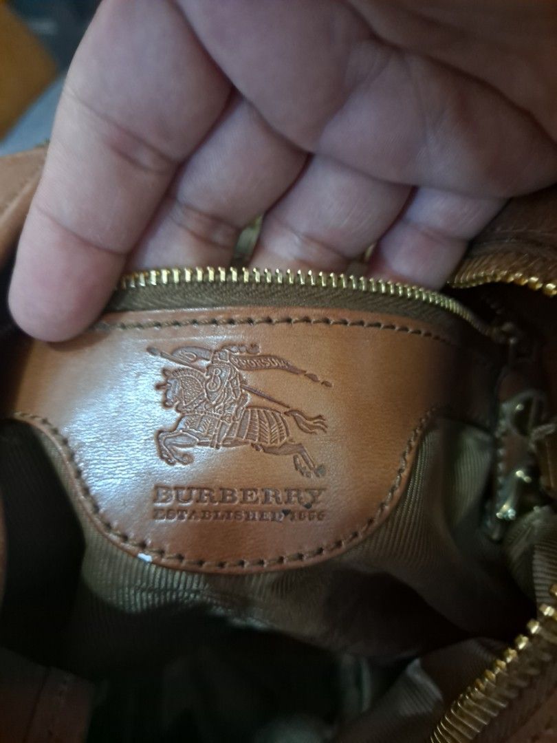 Burberry Hobo Handbag (Category: Luxury Bags & Wallets) located in Cebu City. Submitted by atetskie (Listing ID 1408422922, Image 3). Description: - Authentic Burberry hobo handbag - Textured exterior with leather accents - Stylish curved handle - Secure zipper closure with gold-toned pull - Features a leather tag with the Burberry logo - Made in Italy.