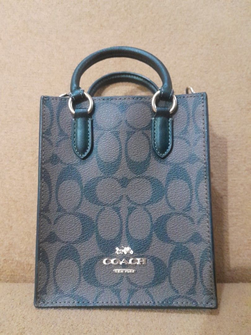 Coach Mini Tote Bag (Category: Luxury Bags & Wallets) located in Quezon City. Submitted by lalaine.r (Listing ID 1408408370, Image 1). Description: - Coach mini tote bag - Signature pattern - Top handle - Detachable shoulder strap - Interior pocket - Gold-tone hardware - Coach logo - Dark color with matching handle - ISSUE: Missing sling.