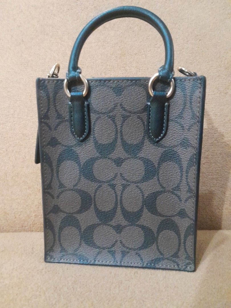 Coach Mini Tote Bag (Category: Luxury Bags & Wallets) located in Quezon City. Submitted by lalaine.r (Listing ID 1408408370, Image 3). Description: - Coach mini tote bag - Signature pattern - Top handle - Detachable shoulder strap - Interior pocket - Gold-tone hardware - Coach logo - Dark color with matching handle - ISSUE: Missing sling.