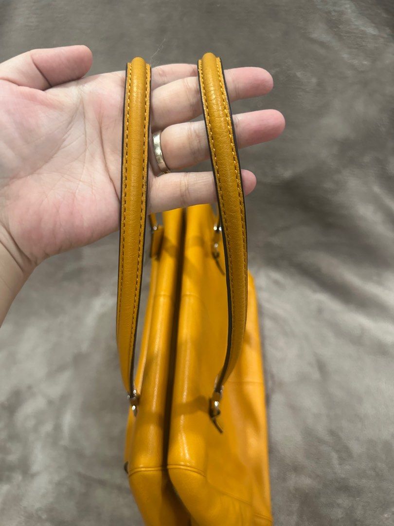 Coach Mustard Yellow Leather Shoulder Bag (Category: Luxury Bags & Wallets) located in Bacolod City. Submitted by katayellow (Listing ID 1408447445, Image 3). Description: Mustard yellow Coach shoulder bag. Features a front pocket with a clasp closure and a top zipper. Includes a detachable shoulder strap. The interior is lined with a blue fabric and has a small pocket. Includes a Coach hangtag. Silver hardware is visible on the bag..