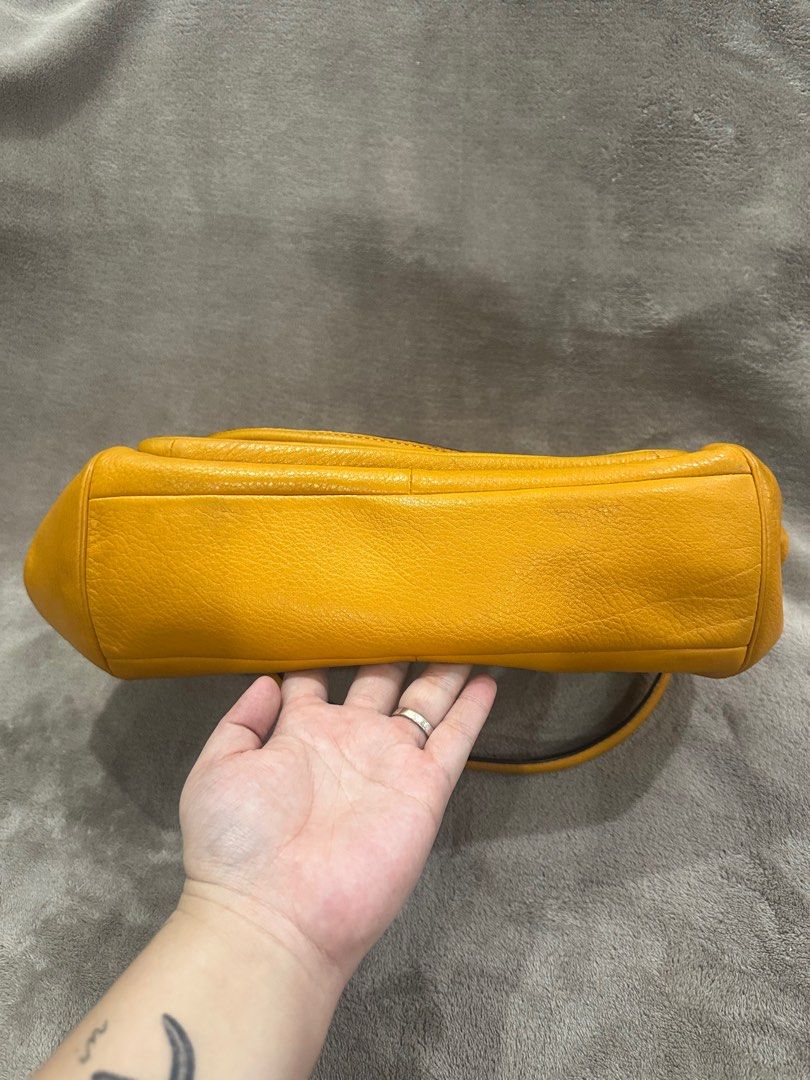 Coach Mustard Yellow Leather Shoulder Bag (Category: Luxury Bags & Wallets) located in Bacolod City. Submitted by katayellow (Listing ID 1408447445, Image 2). Description: Mustard yellow Coach shoulder bag. Features a front pocket with a clasp closure and a top zipper. Includes a detachable shoulder strap. The interior is lined with a blue fabric and has a small pocket. Includes a Coach hangtag. Silver hardware is visible on the bag..