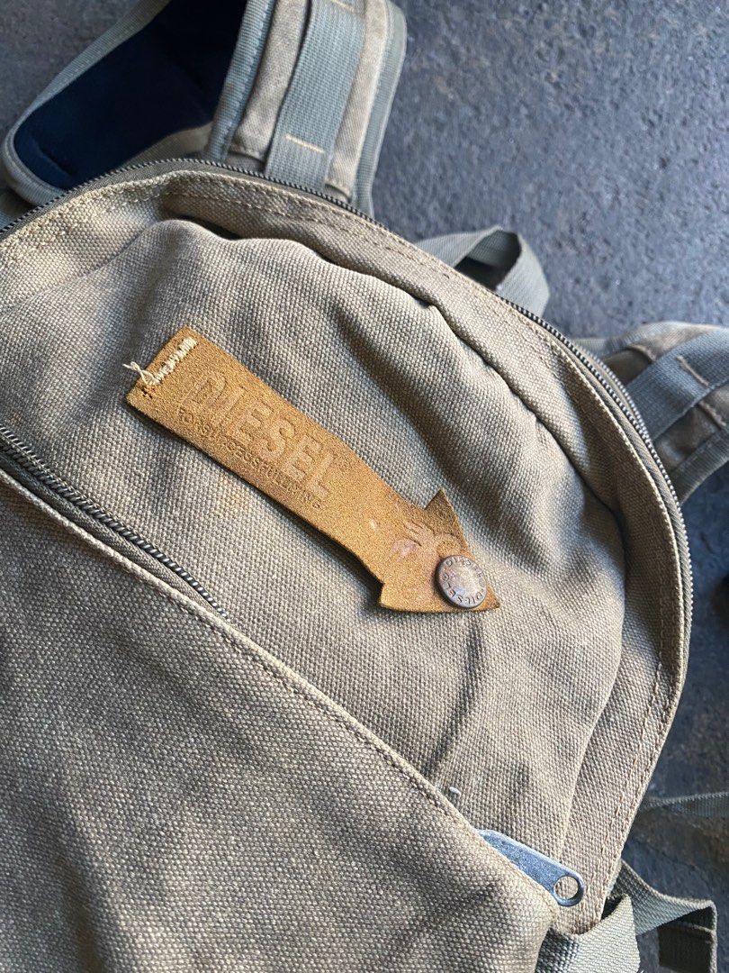 Diesel Canvas Backpack (Category: Backpacks) located in Mabalacat. Submitted by carlatencredi (Listing ID 1408383041, Image 3). Description: - Diesel backpack - Tan color - Multiple compartments - Adjustable straps - Zipper closure main compartment - Several smaller pockets - Diesel logo on front and inside - Durable canvas material -Flaws: Inside zipper see last photo, Need rewash..