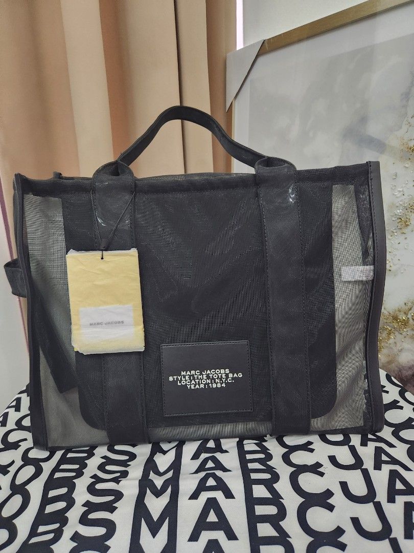 Authentic Marc Jacobs The Tote Bag (Category: Luxury Bags & Wallets) located in Quezon City. Submitted by simpleshaine04 (Listing ID 1408334908, Image 2). Description: - Authentic Limited Edition Marc Jacobs The Tote Bag - Black mesh design - Features brand name display - Includes detachable pouch - Comes with original tags - Includes Marc Jacobs paper bag - Ideal for everyday use - Stylish accessory.