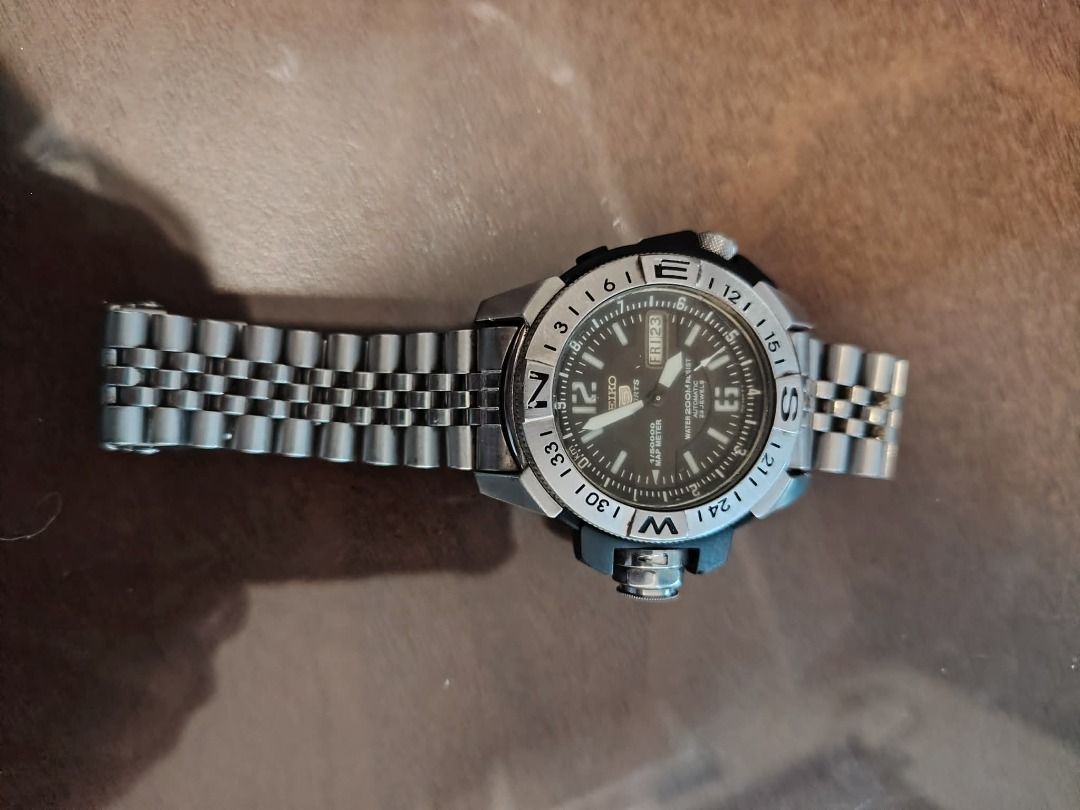Seiko 5 Sports Map Meter Watch (Category: Men's Watches) located in Cavite. Submitted by blackrain4 (Listing ID 1408382776, Image 2). Description: Seiko 5 Sports watch features a black dial with day and date display. It has a map meter function and is water-resistant up to 200m. The watch has a stainless steel bracelet and a rotating bezel. The dial includes the text "1/50000 MAP METER" and "23 JEWELS". Authentic. .
