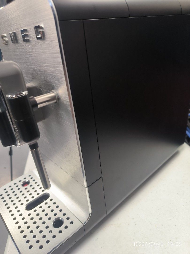 Smeg Espresso Machine (Category: Coffee Machines & Makers) located in Pulilan. Submitted by srtidon (Listing ID 1408324797, Image 3). Description: - Smeg espresso machine BCC 12 - Sleek design with stainless steel front and black body - Features a steam wand - Includes a drip tray - Comes with original packaging and manual.
