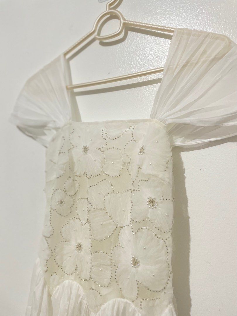 Suna Studio Luzia White Dress (Category: Dresses) located in Mandaluyong City. Submitted by cathyyy21 (Listing ID 1408384089, Image 2). Description: Used twice. Selling for 2,500 - Off-shoulder puff sleeves - Embroidered bodice with sculpted waist - Flowing tulle skirt with soft pleats - Lightweight mesh with floral embroidery - Soft tulle overlay skirt - Fully lined for comfort - Available in size S.