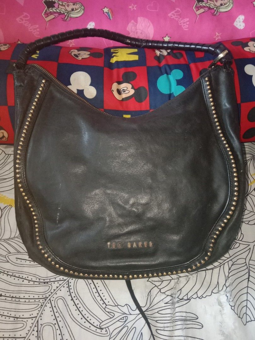 Ted Baker Black Studded Hobo Bag (Category: Luxury Bags & Wallets) located in Bulacan. Submitted by chubbylicious (Listing ID 1408386993, Image 1). Description: - Black Ted Baker hobo bag - Gold-tone stud details - Braided handle - Secure zip closure - Patterned interior lining - Made from genuine leather - Includes interior pockets - Features the Ted Baker logo.