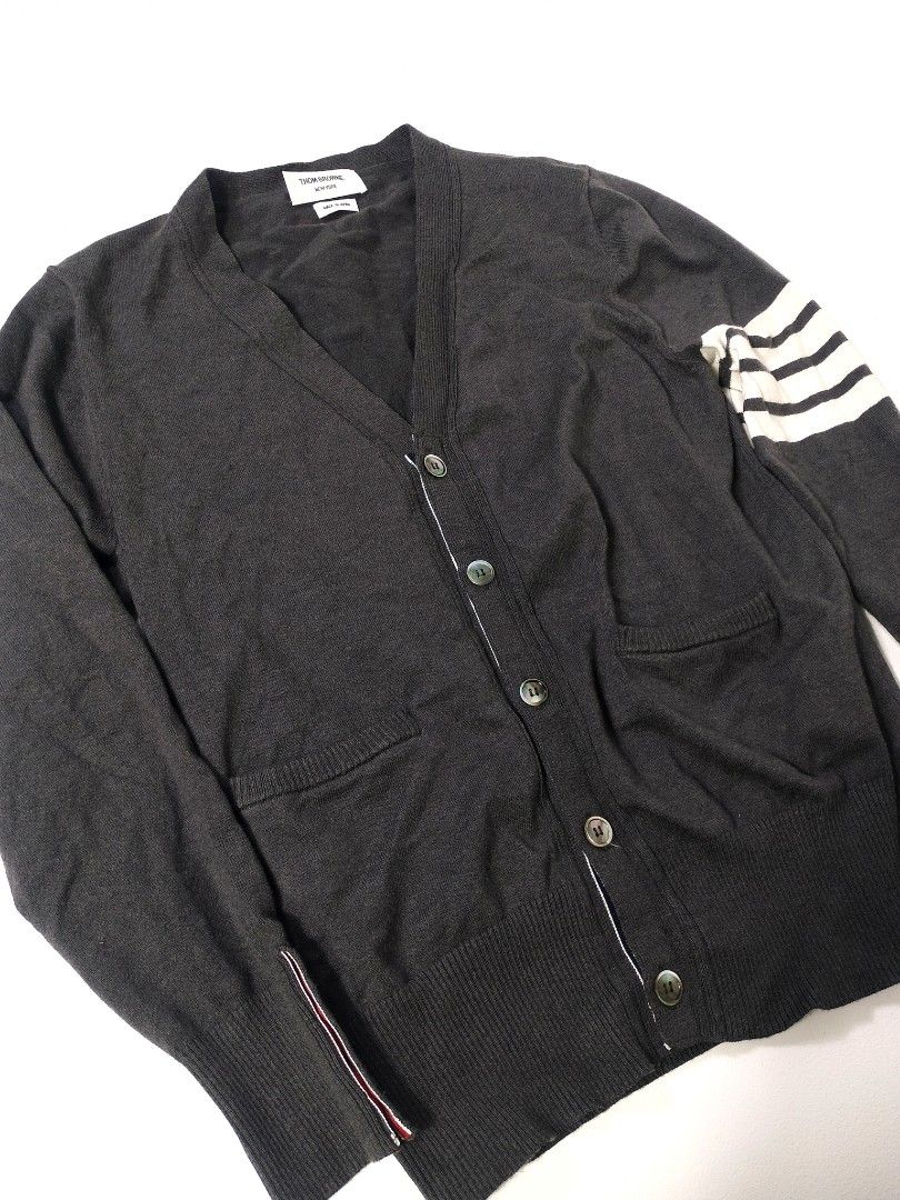 Thom Browne Grey Cardigan (Category: Luxury Apparel) located in Manila. Submitted by callmetin (Listing ID 1408304861, Image 3). Description: Grey cardigan from Thom Browne. Features the signature white stripes on the left sleeve and buttoned cuffs. Made in Japan. The label indicates the material is 50% wool and 50% acrylic. Size 3..