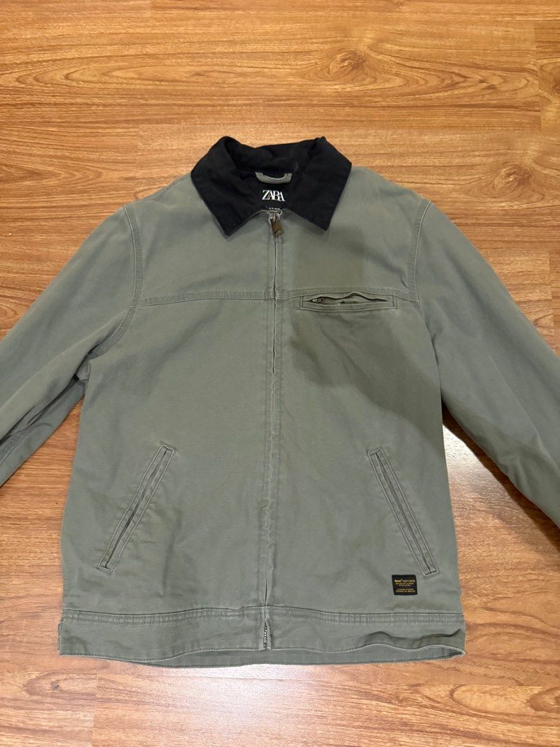 Zara Workwear Jacket (Category: Coats, Jackets and Outerwear) located in Paranaque City. Submitted by declutterhead (Listing ID 1408479302, Image 1). Description: - Negotiable - Zara workwear jacket - Black collar - Zip closure - Multiple pockets - Small logo patch - Durable material - Solid color (green or grey).