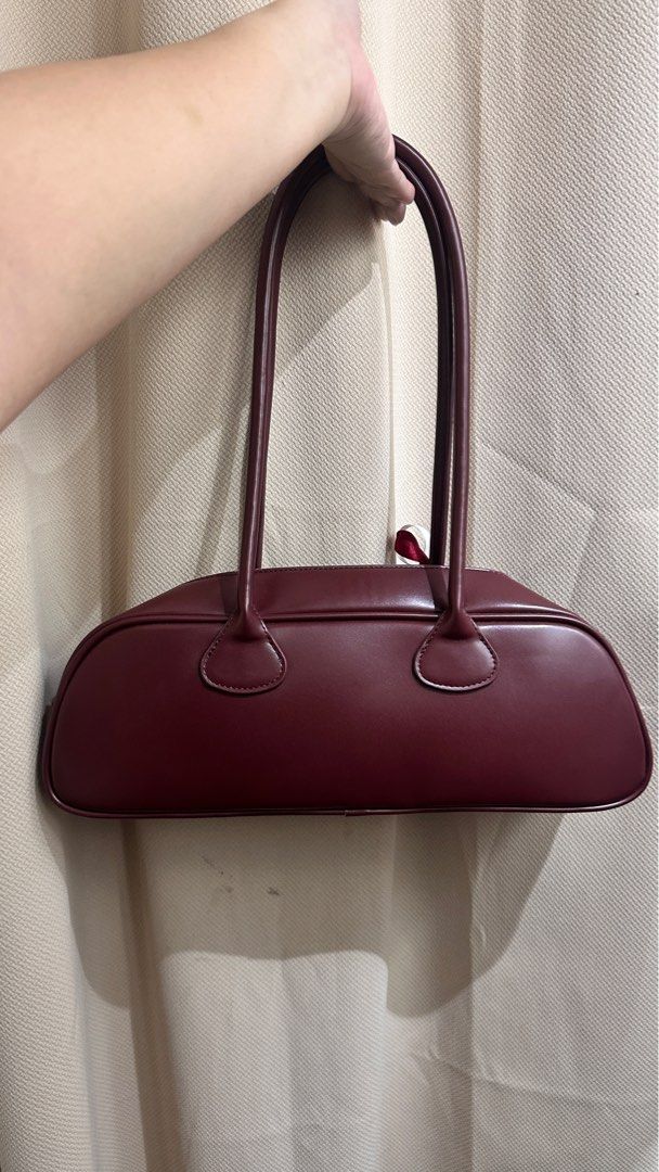 Bagette Burgundy Bag (Category: Luxury Bags & Wallets) located in Muntinlupa City. Submitted by manikkamorota (Listing ID 1408622459, Image 3). Description: - Kendi shoulder bag in a rich burgundy color. - Features a secure zip closure. - Includes a long handle for comfortable carrying. - Comes with a dust bag for storage. - Subtle logo detail on the front. - Branded tag inside for authenticity. - Interior is lined..