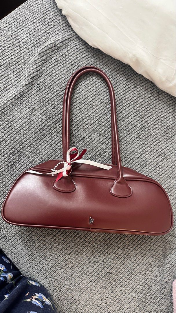Bagette Burgundy Bag (Category: Luxury Bags & Wallets) located in Muntinlupa City. Submitted by manikkamorota (Listing ID 1408622459, Image 2). Description: - Kendi shoulder bag in a rich burgundy color. - Features a secure zip closure. - Includes a long handle for comfortable carrying. - Comes with a dust bag for storage. - Subtle logo detail on the front. - Branded tag inside for authenticity. - Interior is lined..