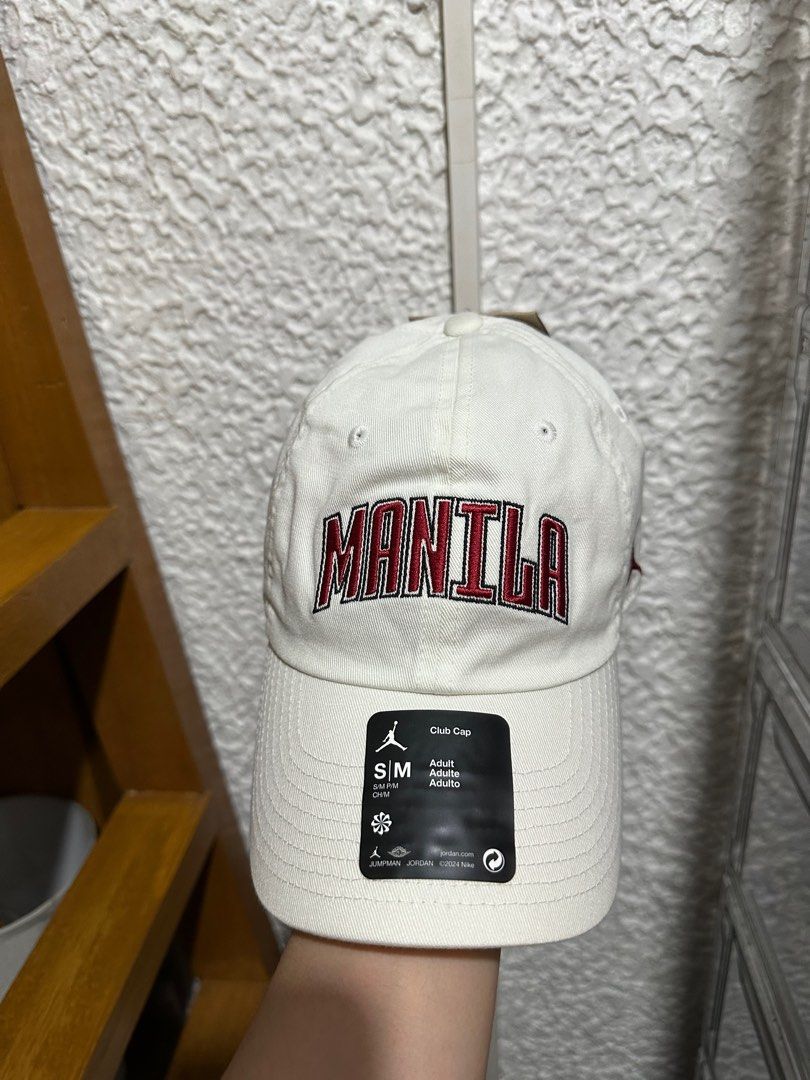 Jordan Manila Club Cap (Category: Caps & Hats) located in Mandaluyong City. Submitted by lmrp3 (Listing ID 1408582328, Image 1). Description: - Jordan Club Cap - Features "MANILA" embroidery - Color: White cap with red embroidery - Size: Adult S/M - Design: Curved brim, adjustable strap - Jordan logo on the side Brand new with tag.