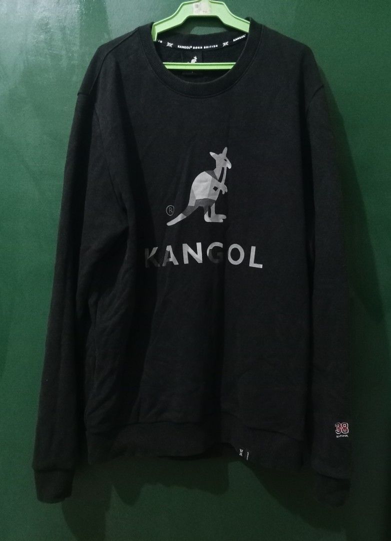 Kangol Black Sweatshirt (Category: Coats, Jackets and Outerwear) located in Manila. Submitted by borromeoem33688 (Listing ID 1408543378, Image 1). Description: Black Kangol sweatshirt with a kangaroo logo on the front. Features a crew neck and long sleeves. The brand name is printed in white below the logo. There is a small logo on the bottom right of the sweatshirt. The neckline has the Kangol logo printed on it..