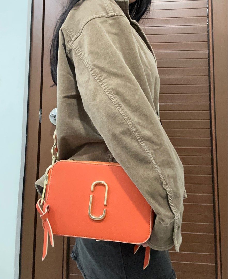Marc Jacobs The Box Bag (Category: Luxury Bags & Wallets) located in Manila. Submitted by rfibe (Listing ID 1408668583, Image 2). Description: - Orange Marc Jacobs The Box Bag - Detachable orange and white strap - Gold-tone logo and hardware - Rectangular shape with zip closure - Features a small leather tassel - Worn crossbody - has flaws, dm me.