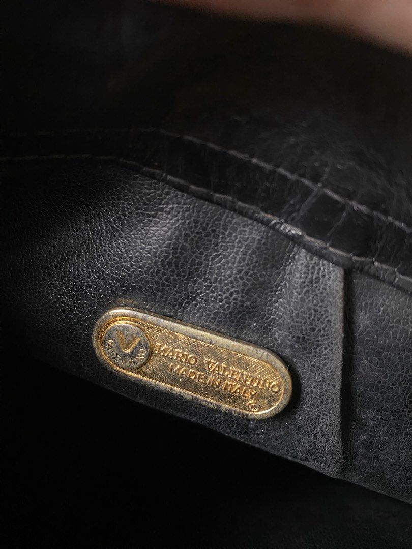 Mario Valentino Black Clutch (Category: Luxury Bags & Wallets) located in Cavite. Submitted by rmquin05 (Listing ID 1408596731, Image 3). Description: - Mario Valentino clutch bag - Black color - Embossed brand name - Flap closure with metal clasp - Interior lining shows wear and tear - Made in Italy.