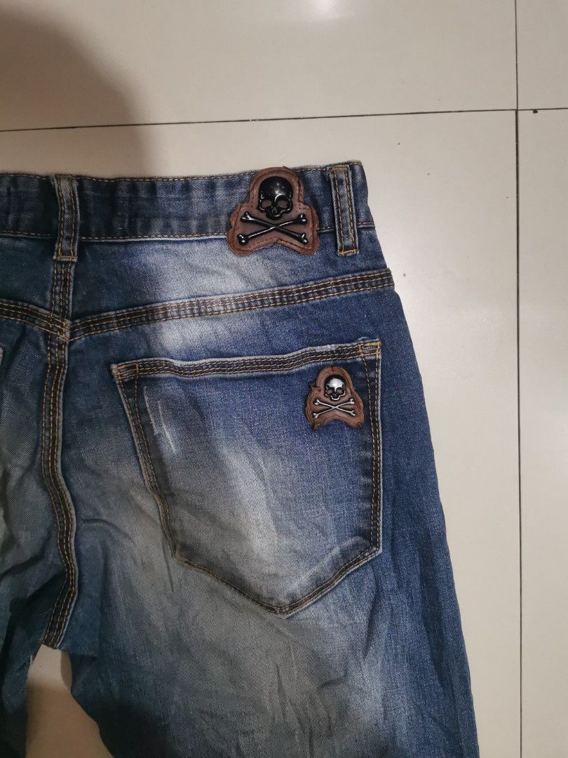 Phillip Plein Edition Vintage Jeans (Category: Jeans) located in Davao. Submitted by dmp1993 (Listing ID 1408600699, Image 3). Description: Stylish Phillip Plein jeans in a classic blue wash. Features a button closure and a straight leg fit. Includes unique skull patches on the back pockets. Waist measures approximately 14 inches across. The length from waist to hem is about 40 inches. The inseam is around 30 inches. A great addition to any wardr