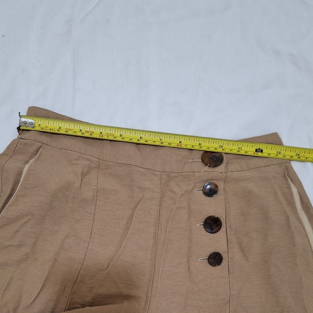 Topshop Petite Wide Leg Pants (Category: Other Bottoms) located in Pasig City. Submitted by avcan (Listing ID 1408661015, Image 3). Description: Stylish Topshop Petite wide-leg pants in a versatile tan color. Features a button closure and two front pockets. The pants are a size UK6 and made in Vietnam. The waist measures approximately 14 inches across, when laid flat. Length is about 30.5 inches. .