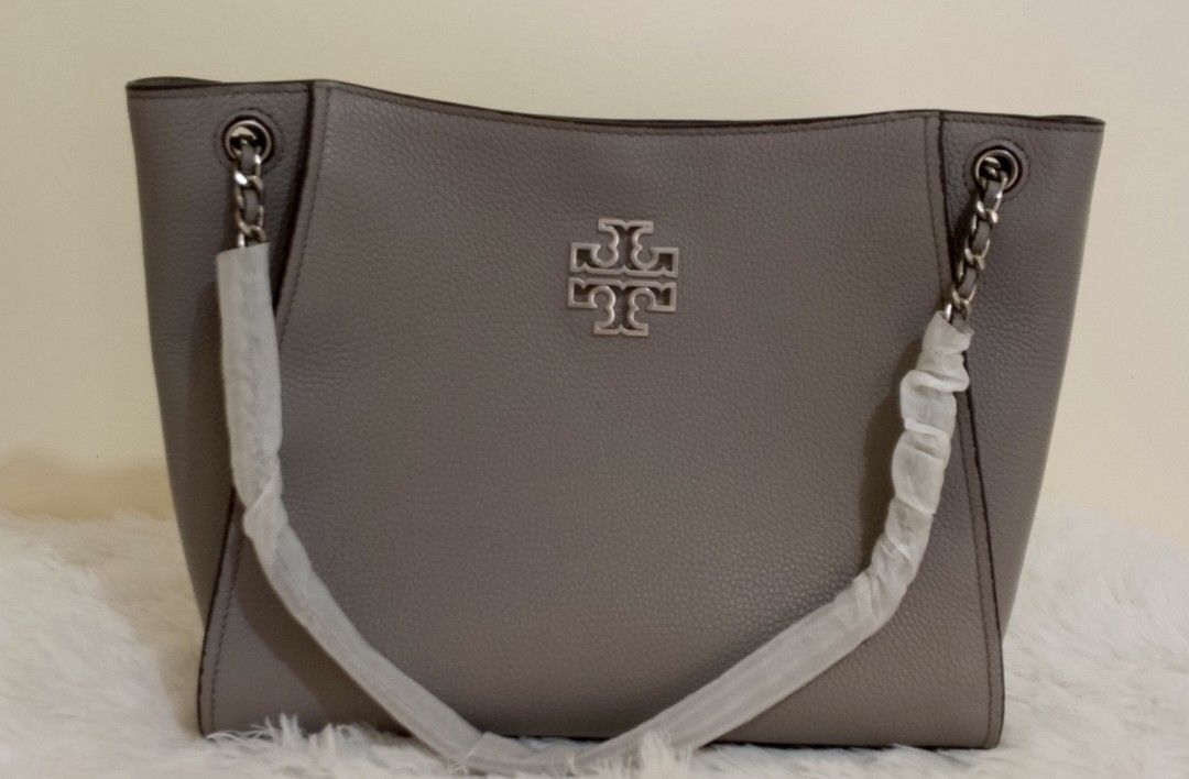 Tory Burch Gray Tote Bag in pebbled (Category: Luxury Bags & Wallets) located in Bacolor. Submitted by pinktintmine (Listing ID 1408561706, Image 1). Description: - Gray Tory Burch tote bag - Silver chain straps - Silver Tory Burch logo - Includes a long strap - Made of leather.