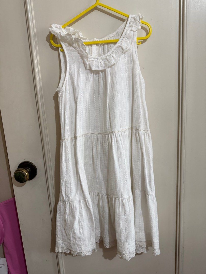 White Sleeveless Tiered Dress (Category: Babies & Kids Fashion) located in Quezon City. Submitted by well.lovedph (Listing ID 1408517793, Image 1). Description: White sleeveless dress with a tiered design. Features a ruffled neckline and decorative buttons down the back. The dress has a textured fabric and a lace trim at the hem. .