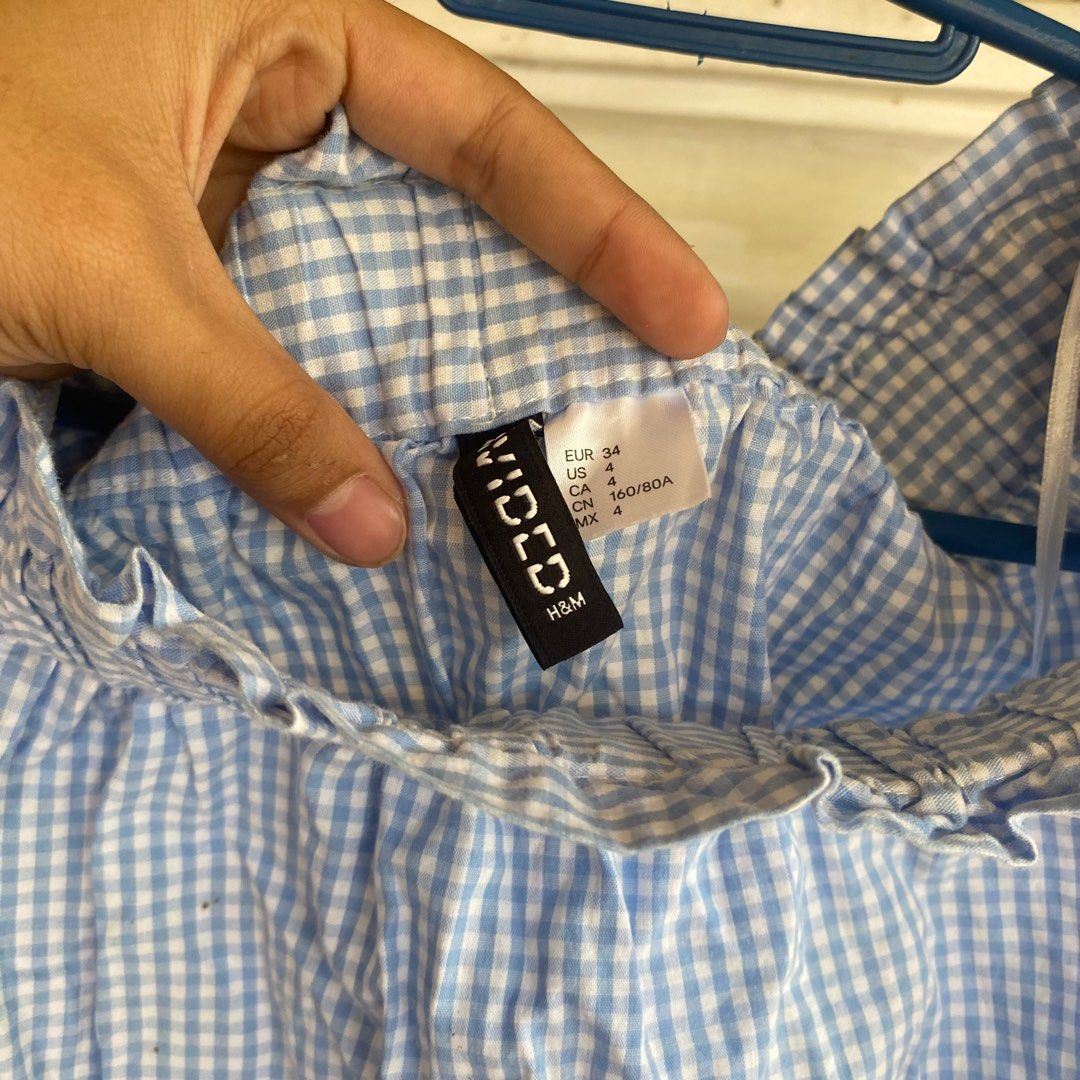 H&M Divided Off-Shoulder Top (Category: Blouses) located in Caloocan City. Submitted by ven_thrifts (Listing ID 1408795447, Image 3). Description: - H&M Divided top - Blue and white checkered pattern - Off-shoulder design - Long sleeves - Tie details at cuffs - Size 4 - Suitable for various occasions.