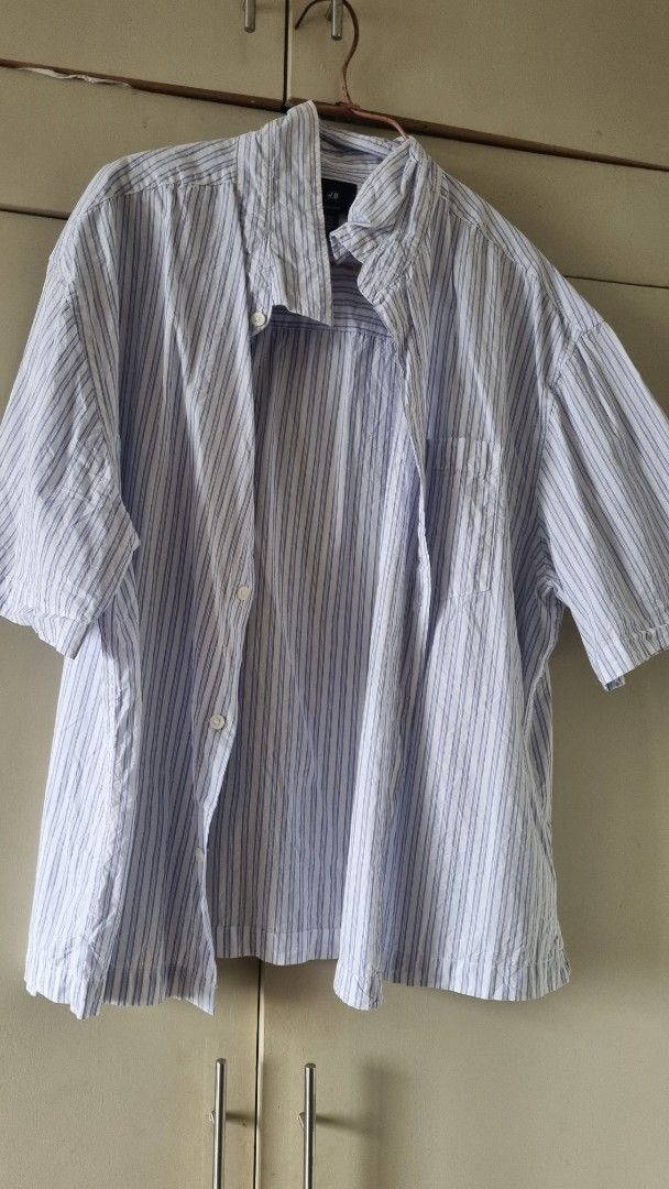 H&M Regular Fit Striped Shirt - XL (Category: Tshirts & Polo Shirts ) located in Manila. Submitted by cssunriseph (Listing ID 1408748967, Image 1). Description: H&M Regular Fit shirt in a striped pattern. Features a button-down design with long sleeves. The shirt is a light blue and white color. Size is XL. Made from a lightweight fabric, suitable for casual wear. The shirt has a classic collar and a single chest pocket..