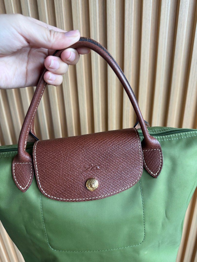 Longchamp Le Pliage Small Handbag (Category: Luxury Bags & Wallets) located in Lipa City. Submitted by thyra06 (Listing ID 1408807746, Image 3). Description: - Authentic Longchamp Le Pliage handbag - Classic green color - Brown leather flap and handles - Secure zipper closure - Spacious interior - Longchamp logo detail - Made in France - Minimal signs of wear - Clean interior.