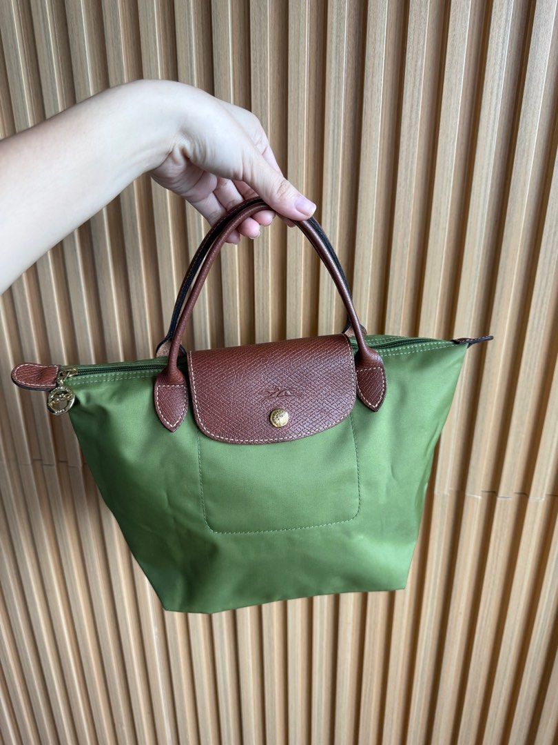 Longchamp Le Pliage Small Handbag (Category: Luxury Bags & Wallets) located in Lipa City. Submitted by thyra06 (Listing ID 1408807746, Image 1). Description: - Authentic Longchamp Le Pliage handbag - Classic green color - Brown leather flap and handles - Secure zipper closure - Spacious interior - Longchamp logo detail - Made in France - Minimal signs of wear - Clean interior.