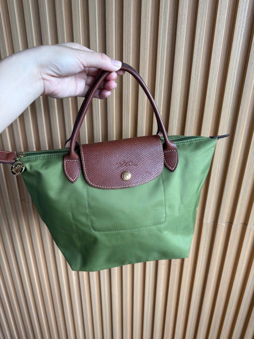 Longchamp Le Pliage Small Handbag (Category: Luxury Bags & Wallets) located in Lipa City. Submitted by thyra06 (Listing ID 1408807746, Image 2). Description: - Authentic Longchamp Le Pliage handbag - Classic green color - Brown leather flap and handles - Secure zipper closure - Spacious interior - Longchamp logo detail - Made in France - Minimal signs of wear - Clean interior.
