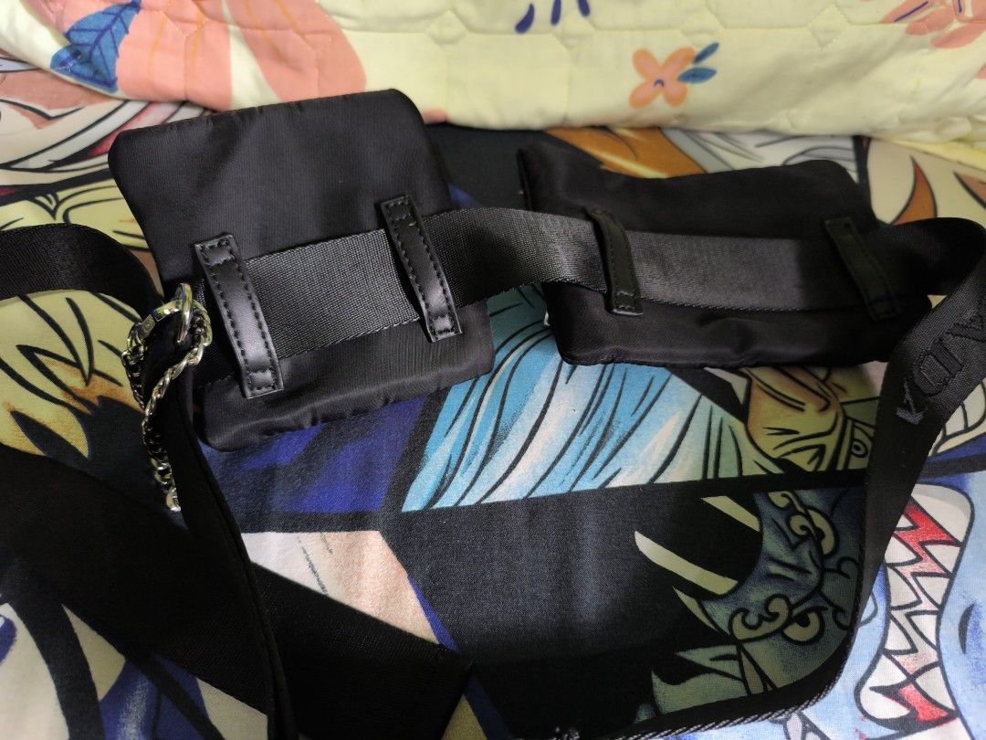 Prada Black Waist Bag (Category: Luxury Bags & Wallets) located in Rizal. Submitted by archive_silhouette (Listing ID 1408723073, Image 2). Description: - Prada waist bag - Color: Black - Features two pouches - Silver-tone buckle with Prada logo - Prada logo embossed interior - Includes chain and strap with Prada logo - Made in Italy.