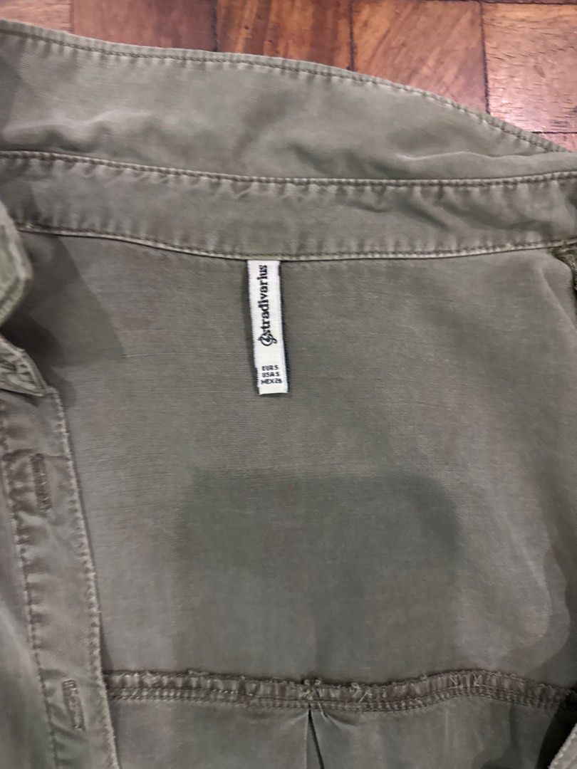 Stradivarius Olive Green Shirt (Category: Shirts) located in Manila. Submitted by mbpte (Listing ID 1408721984, Image 2). Description: - Stradivarius olive green shirt - Size: EUR S, USA S, MEX 26 - Features: Button-down front, two chest pockets, long sleeves - Fit: Relaxed - Hemline: Curved - Fabric: Soft, lightweight.