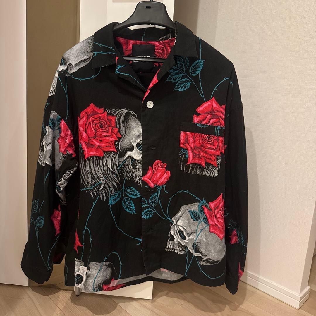 Yohji Yamamoto Wildside Skull and Rose Print Shirt (Category: Tshirts & Polo Shirts) located in Singapore. Submitted by v1ntagecollector1 (Listing ID 1408730527, Image 1). Description: - Black long-sleeved shirt - Features a skull and rose print - Button-down front - Includes a pocket - Suitable for casual wear or nights out.