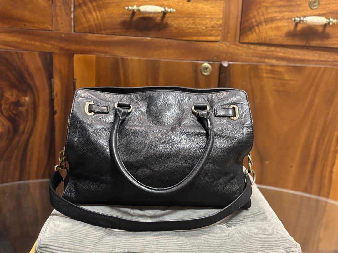 Original Preloved MK Hamilton black (Category: Luxury Bags & Wallets) located in Imus. Submitted by bagsofblessings24 (Listing ID 1350633878, Image 2). Description: Original Michael Kors Hamilton 2way Black, medium size Genuine soft leather 3 main compartments with inside pockets Good hardwares Minimal signs of use on the hardware Only flaw - one side of the back handle lost inside support (common with Hamilton) Length 14in X Height 11in x Width 