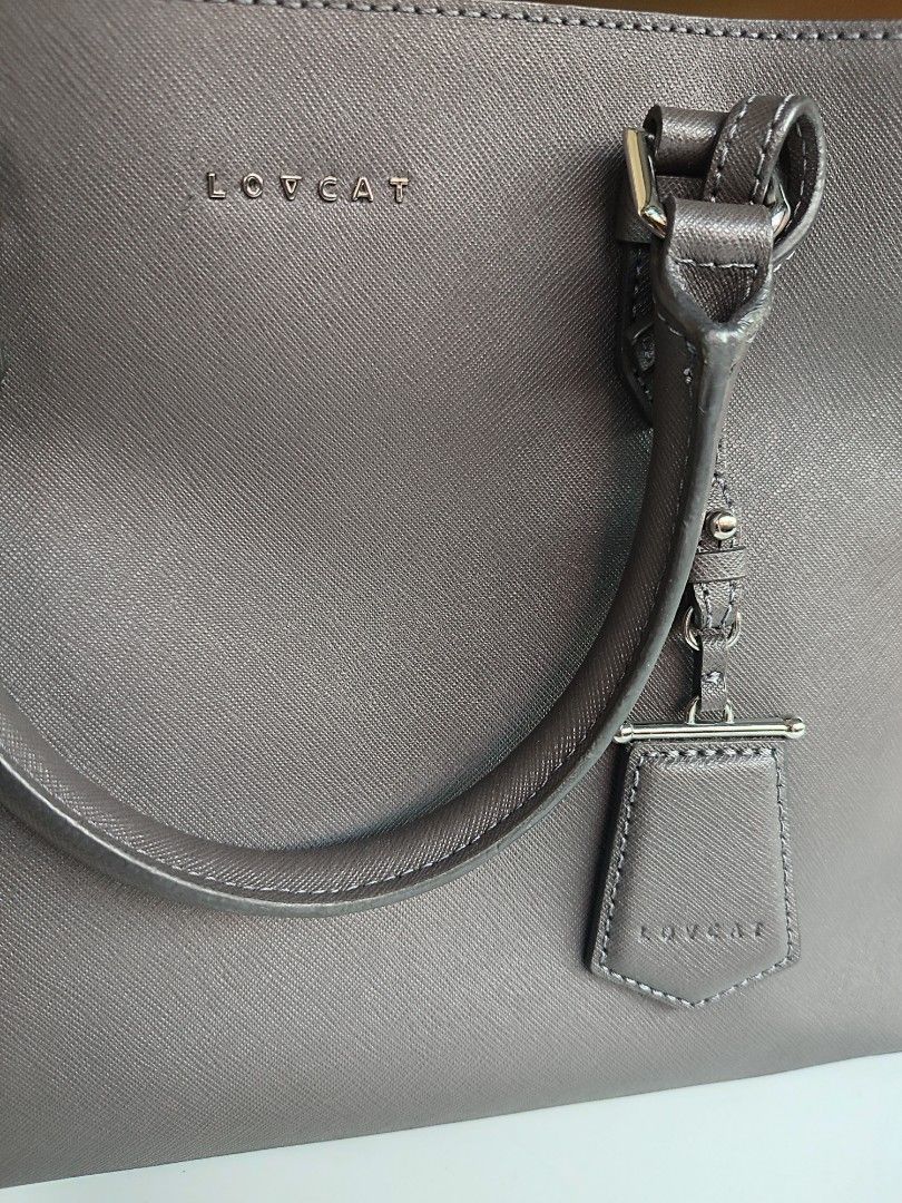 LOVCAT two-tone top handle bag (Category: Luxury Bags & Wallets) located in San Pedro. Submitted by thesimplesatchelph (Listing ID 1352296451, Image 3). Description: Lovcat top handle bag Excellent used condition Saffiano leather Gray and old rose color combination Canvas interior Minimal signs of use - almost no flaw except for a tiny scratch beside the logo No sling included MOP: GCash.