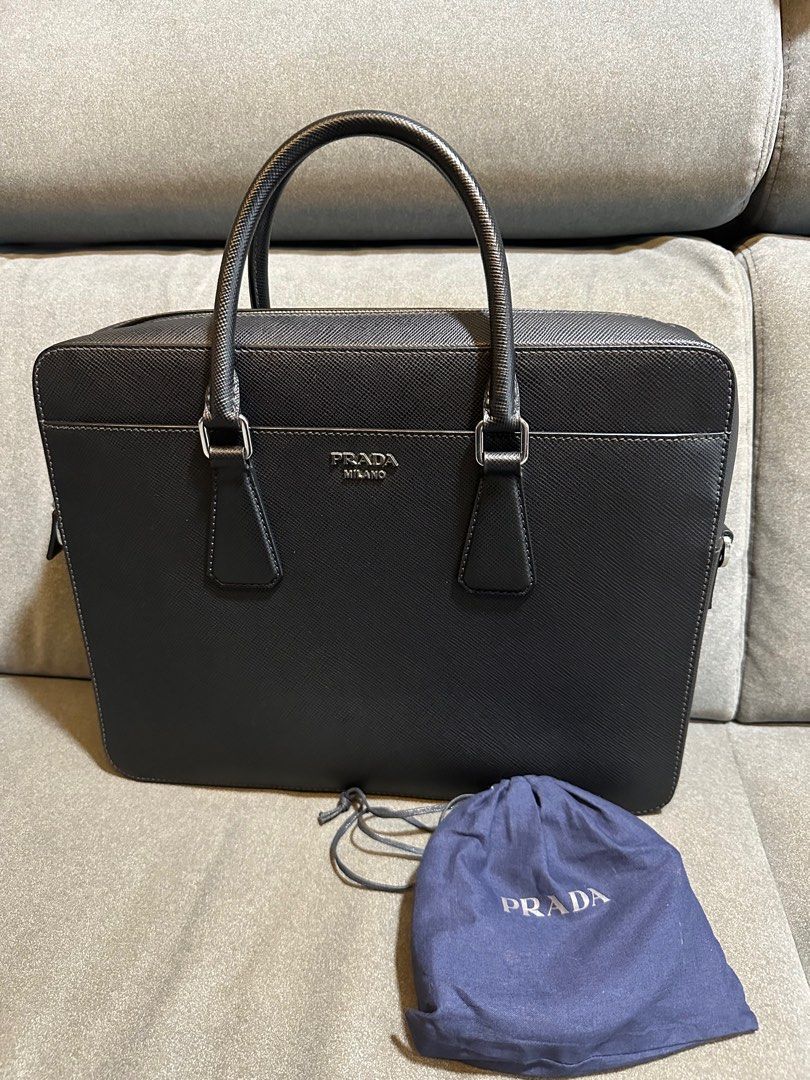 Prada Saffiano Leather Briefcase / Business Bag (Category: Bags & Wallets) located in Singapore. Submitted by cjyong (Listing ID 1353068127, Image 1). Description: Prada briefcase as good as new. Used only for a couple of times. Shoulder strap is new and unused before. Briefcase in Saffiano leather. Prada lettering in metal..